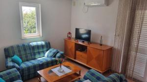 un salon avec deux canapés et une télévision dans l'établissement Apartment Relax, à Mandre