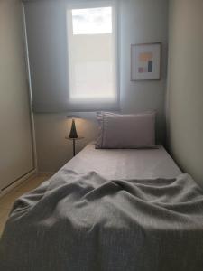 een bed in een slaapkamer met een raam erboven bij Apartamento Urbano 02 dormitórios in Marília
