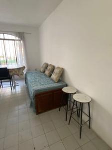 コスキンにあるApartamento El Gauchito en Cosquinのベッド1台とスツール2脚が備わる客室です。