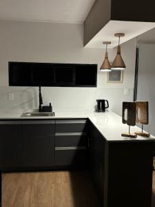 una cucina con ripiani in bianco e nero e un lavandino di casa moderna a Durazno