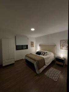una camera da letto con un letto grande e una TV di casa moderna a Durazno