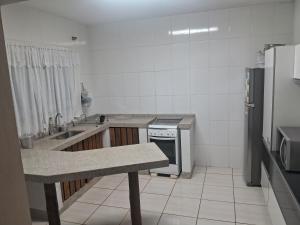 een kleine keuken met een spoelbak en een koelkast bij Casa in Socorro +3 foto's