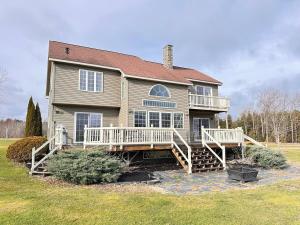 a large house with a large porch and a deck at Lake House in Newport Maine in Loon Island