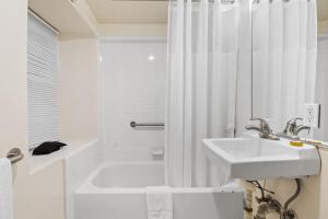 a bathroom with a white shower curtain and a sink at Fitzgerald Hotel Union Square in San Francisco +20 photos
