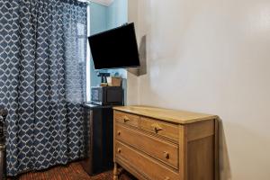 a bedroom with a dresser with a television on top of a dresser at Fitzgerald Hotel Union Square in San Francisco
