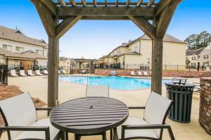 Un patio con mesa y sillas y una piscina. en HYDR Comfy Condo Less2 mi to OM, en Oxford