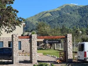 a sign in front of a building with a mountain at Hotel Boutique con Desayuno in Tafí del Valle