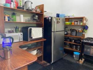 eine Küche mit einem Kühlschrank aus Edelstahl und einem Tisch in der Unterkunft Calandria Mountain House in Monteverde Costa Rica + 15 Fotos