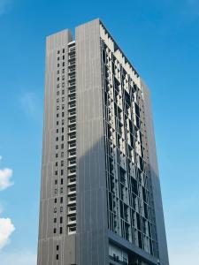 a tall glass building with a blue sky in the background at Chamber KL Residence by Moon Orchid in Kuala Lumpur