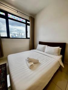 a bed with a towel on it with a window at Chamber KL Residence by Moon Orchid in Kuala Lumpur