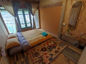 a small bedroom with a bed and a rug at Little House in KhauPha, Mu Cang Chai - homestay, cuisine, cafe in Mù Cang Chải