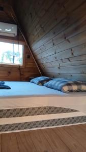 two beds in a room with a wooden ceiling at Cabana Villa Caju in Praia dos Algodões