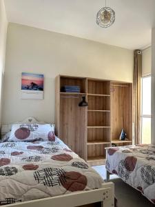 a bedroom with two beds and a window at Appart Neuf Calme et Proche in Branes +17 photos