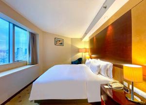 a bedroom with a large white bed and a window at Radisson Collection Hyland Shanghai in Shanghai
