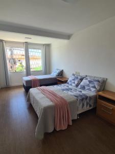 a bedroom with a bed and a couch in it at Casa duplex, 400m da praia e 13min do Beto Carrero in Piçarras