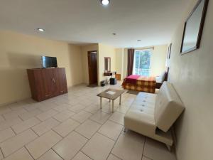 een woonkamer met een bank en een bed bij Hotel Ciprés Puebla in La Concepción