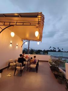 芹苴Experience Homestay的一群人坐在阳台上的桌子上