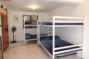 a room with three bunk beds in a room at Puting Bakod- Vacation Home with Mountain & Lake View in Jalajala