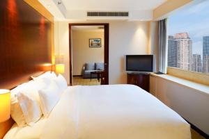 a hotel room with a large white bed and a window at Radisson Collection Hyland Shanghai in Shanghai