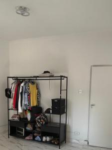 a room with a shelf with clothes and a mirror at Residência Ruiz in Sao Paulo