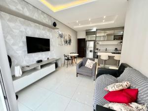 a living room with a couch and a tv on a wall at Sinop Luxury Apartment in Sinop