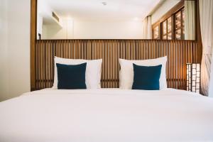 a bedroom with a large bed with blue pillows at Le Sen Boutique Hotel in Luang Prabang +100 photos