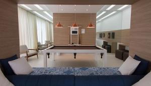 a living room with a blue couch and a table at Lindo Apto entre 2 praias in Bertioga