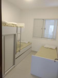 a room with two bunk beds and a window at Lindo Apto entre 2 praias in Bertioga