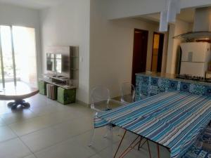 a kitchen with a glass table and a counter top at Lindo Apto entre 2 praias in Bertioga