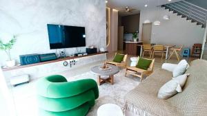 a living room with a couch and a tv at Serenity Haven in Sungai Besar