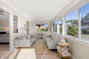 a living room with two couches and a table at Beachhouse Currarong - Pet Friendly Beachfront in Currarong