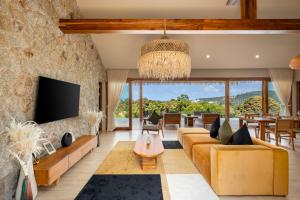 an open living room with a large stone wall at Wild Cottages Elephant Sanctuary Resort in Bophut 