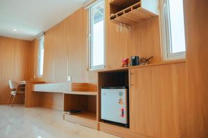 Una cocina con un refrigerador blanco en una pared de madera. en The Elephant Crossing Hotel, en Vang Vieng