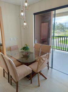 ein Esszimmer mit Glastisch und Stühlen in der Unterkunft Apto 2 quartos em Imbituba Santa Catarina in Imbituba