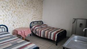 a small room with two beds and a sink at Cuarto independiente doble in Culiacán