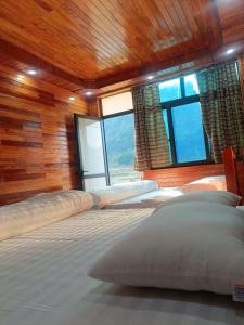 a bedroom with two beds in a room with windows at Điệp HOMESTAY Bản Giốc in Lũng Niêo