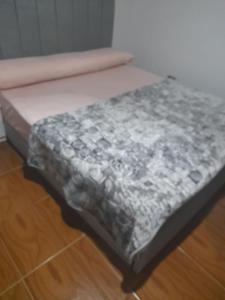 a bed sitting on top of a wooden floor at 2 Bedrooms Apartment beside American University in New Cairo in Cairo