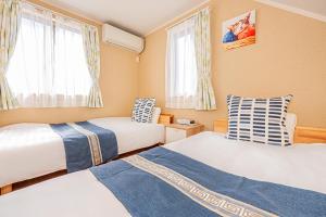 una camera da letto con due letti e due finestre di Shinjuku 新宿区地下鉄駅まで徒歩4分 a Tokyo