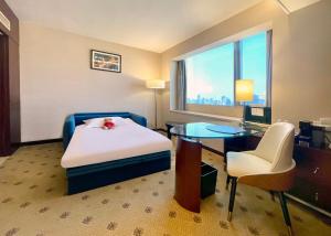 a hotel room with a bed and a desk and a window at Radisson Collection Hyland Shanghai in Shanghai