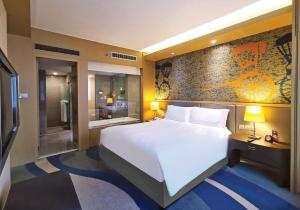a bedroom with a large white bed and a tv at Radisson Collection Hyland Shanghai in Shanghai