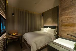 a bedroom with a bed and a sink and a tub at Jiayuguan Tuzhu Hotel in Jiayuguan