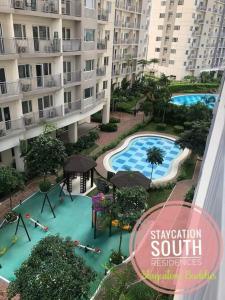 Una vista aérea de una piscina frente a un edificio. en 1br condo unit in smdc South Residences sunset view - 1212T1, en Manila