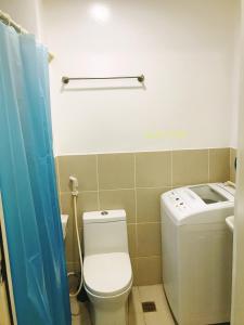 y baño con aseo, lavadora y secadora. en 1br condo unit in smdc South Residences sunset view - 1212T1, en Manila