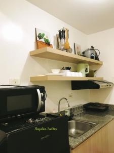 una cocina con fregadero y microondas en 1br condo unit in smdc South Residences sunset view - 1212T1, en Manila 6 fotos más