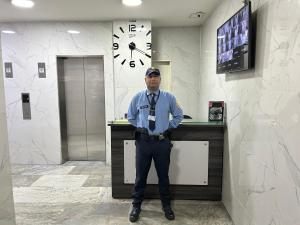 メデジンにあるAcogedor Apto a pasos del metro de Medellín zona centroの時計の前に立つ男