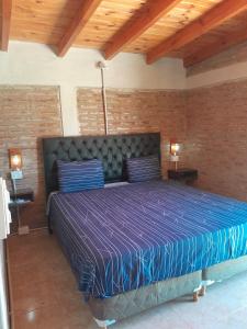 a bedroom with a large bed with a purple comforter at Remanso in La Estancia +35 photos
