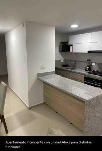 una cucina con mobili bianchi e un piano di lavoro di Lujoso apartamento con aire acondicionado en calle 60 Ibagué Tolima a Ibagué