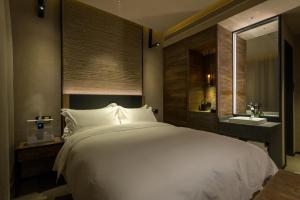 a bedroom with a large white bed and a sink at Jiayuguan Tuzhu Hotel in Jiayuguan