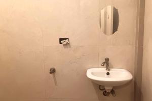 a bathroom with a sink and a phone on the wall at Hotel Villarte Fort Pampanga in San Fernando