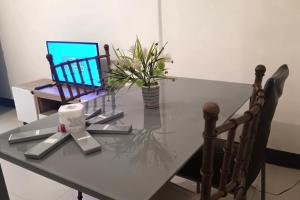 a glass table with a laptop on top of it at Hotel Villarte Fort Pampanga in San Fernando